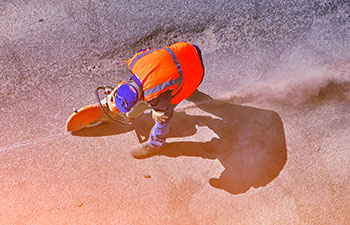worker repairing asphalt parking lot