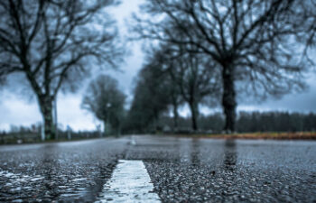 close up of the middle of a wet road with cloudy and rainy weather
