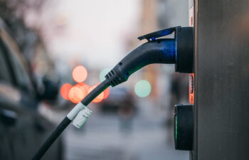 Close-up of an electric car charging station with a car plugged in