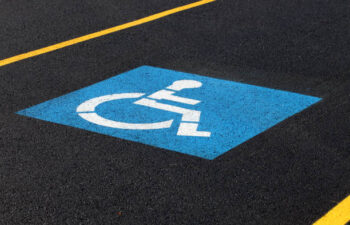 A painted sign marking a reserved handicapped parking space