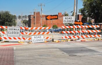 a road closed sign sitting on the side of a road