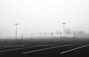 empty asphalt parking lot spaces in fog