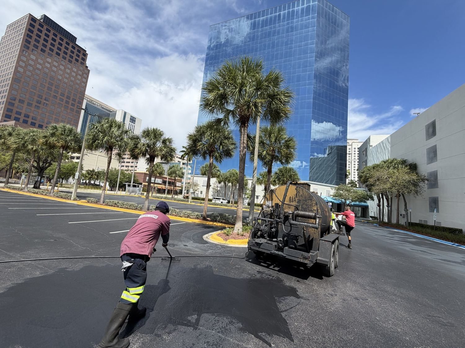 TreadCoat™ sealcoat going down with the downtown skyline overhead.