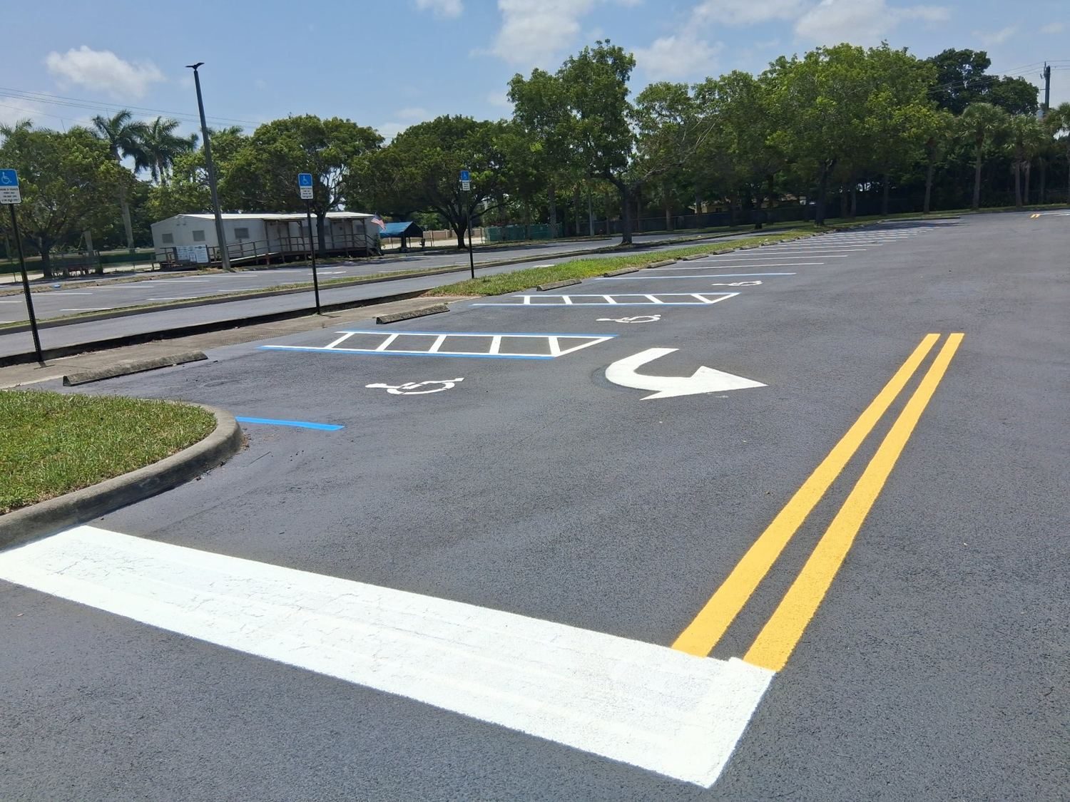Hatched loading zone and double-yellow drive lane at the covered walkway.